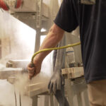 worker blowing off stone dust in a workshop